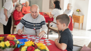 Senior und Junge spielen gemeinsam Memory in der Pflegewohngruppe Hegi – generationenübergreifende Begegnung zwischen Altenpflege und Kinderbetreuung.